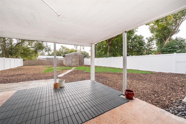 view of patio / terrace featuring an outbuilding, a fenced backyard, and a storage unit