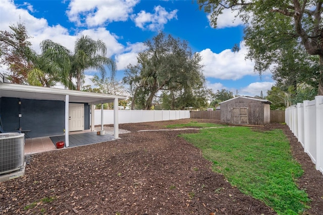 view of yard featuring an outbuilding, a storage unit, a fenced backyard, and central air condition unit