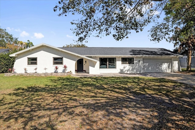 ranch-style house featuring a garage, a front yard, concrete driveway, and stucco siding