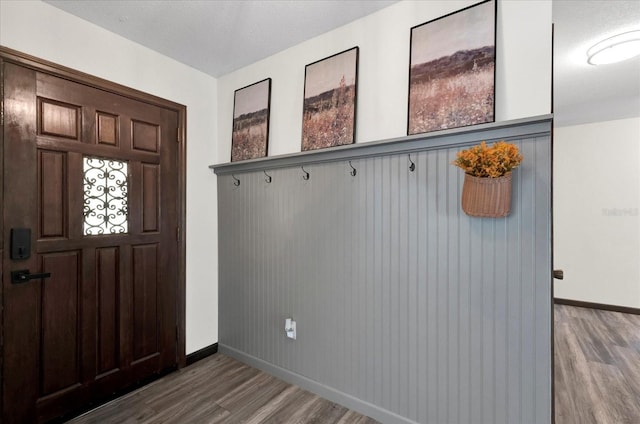 mudroom featuring baseboards and wood finished floors