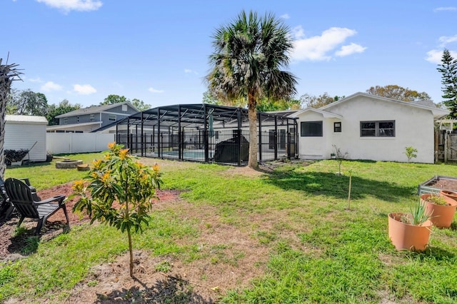 view of yard featuring a lanai, an outdoor fire pit, a swimming pool, and a fenced backyard