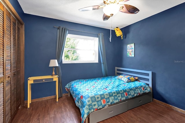 bedroom featuring ceiling fan, a closet, baseboards, and wood finished floors