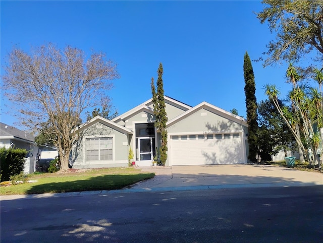 single story home featuring a front lawn, concrete driveway, and a garage