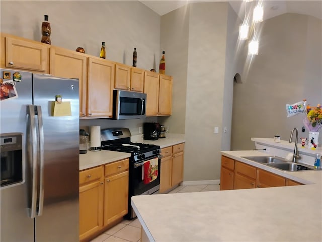 kitchen featuring light tile patterned floors, light brown cabinets, a sink, light countertops, and appliances with stainless steel finishes