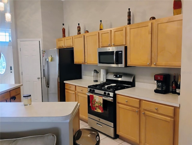 kitchen featuring light countertops, light tile patterned floors, light brown cabinetry, and stainless steel appliances