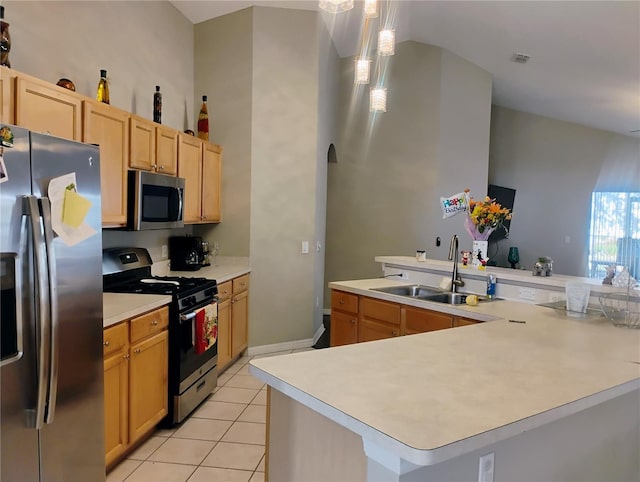 kitchen featuring light countertops, light tile patterned floors, appliances with stainless steel finishes, arched walkways, and a sink