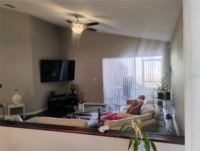 living area with visible vents, baseboards, lofted ceiling, and a ceiling fan