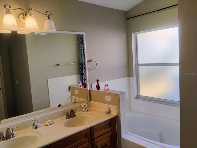 full bath with a bath, double vanity, and a sink