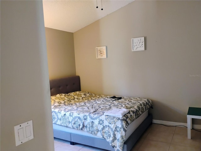 bedroom with light tile patterned flooring and baseboards