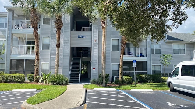 view of building exterior with uncovered parking and stairs