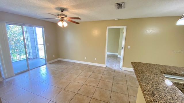 unfurnished room featuring a textured ceiling, light tile patterned floors, and visible vents