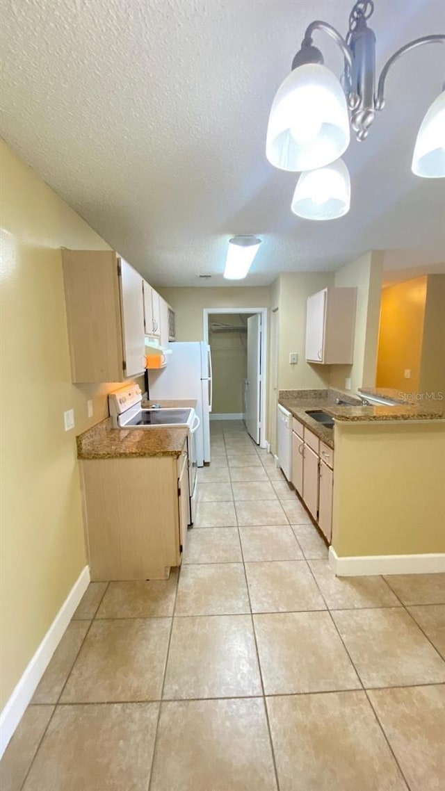 kitchen with pendant lighting, white appliances, baseboards, and light tile patterned floors