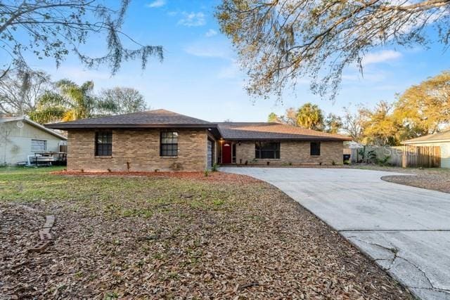 single story home with driveway and fence