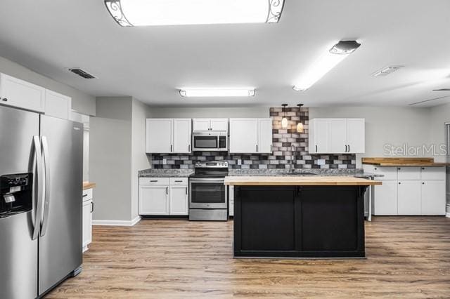 kitchen featuring stainless steel appliances, light countertops, and white cabinetry