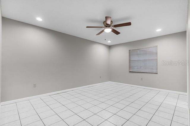 spare room with ceiling fan, light tile patterned floors, recessed lighting, and baseboards