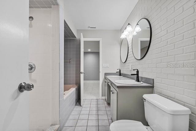 bathroom featuring double vanity, a sink, toilet, and tile patterned floors