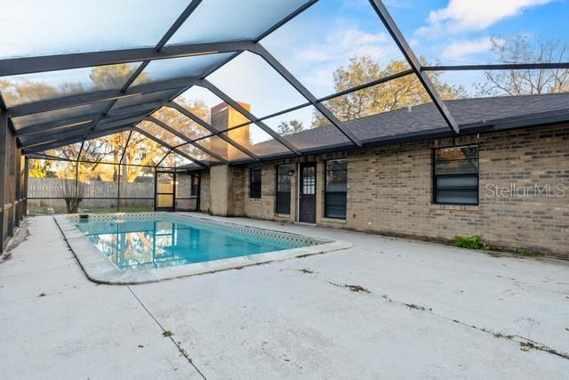 view of pool with a fenced in pool, a patio area, glass enclosure, and fence