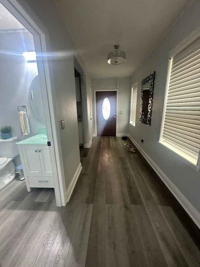 doorway featuring wood finished floors and baseboards