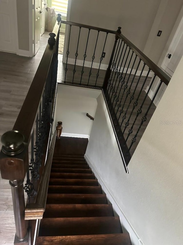 stairway featuring baseboards and wood finished floors