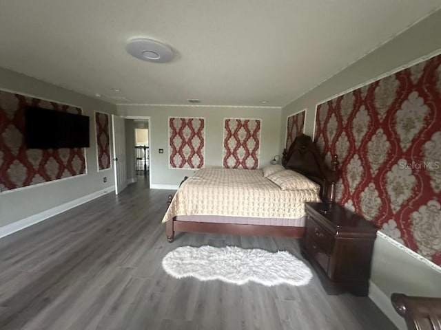 bedroom with wood finished floors and baseboards