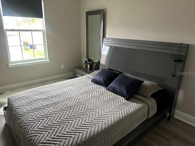 bedroom with baseboards and wood finished floors