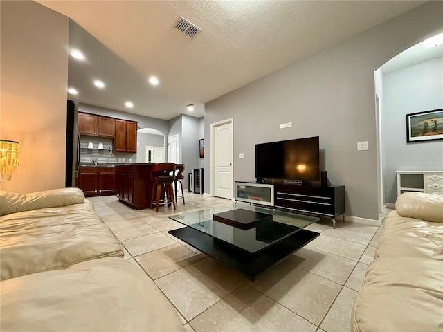 living area with recessed lighting, visible vents, arched walkways, and light tile patterned flooring