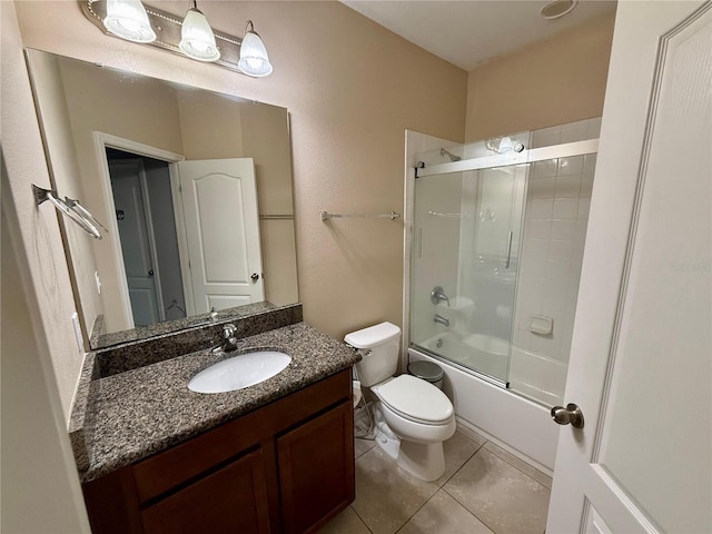 bathroom featuring toilet, tile patterned flooring, enclosed tub / shower combo, and vanity