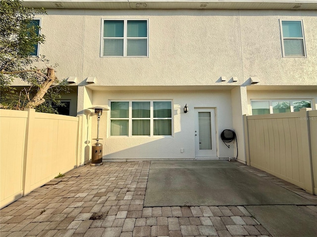 back of property featuring a patio area, fence, and stucco siding