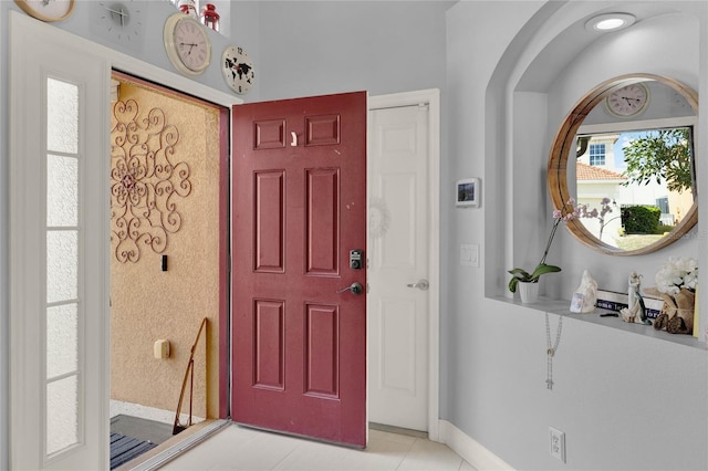 foyer with baseboards and light tile patterned floors