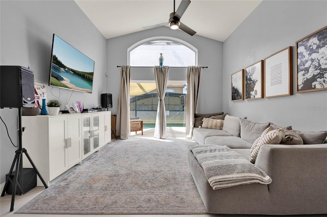 living area featuring vaulted ceiling, a ceiling fan, and light colored carpet