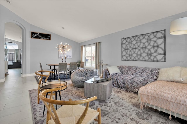 living area featuring arched walkways, an inviting chandelier, vaulted ceiling, tile patterned flooring, and baseboards