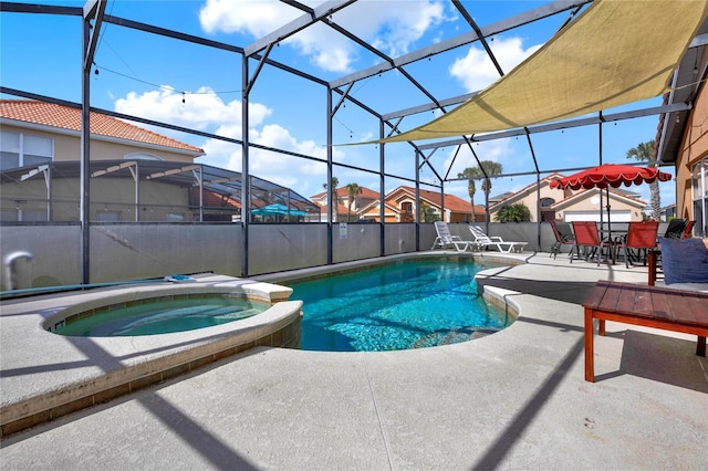 view of swimming pool with glass enclosure, a patio area, and a pool with connected hot tub