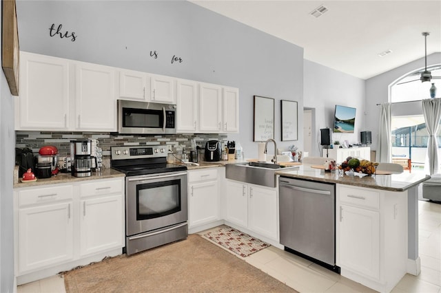 kitchen featuring stainless steel appliances, visible vents, white cabinetry, a sink, and a peninsula