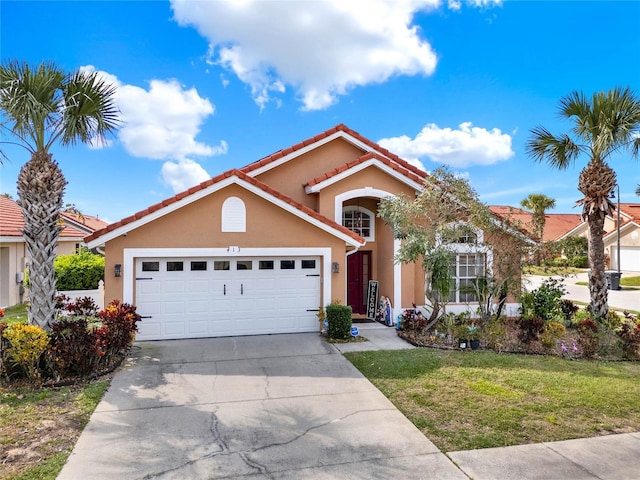 view of front of property featuring a tile roof, stucco siding, an attached garage, a front yard, and driveway