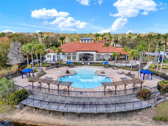 pool with a patio area and fence