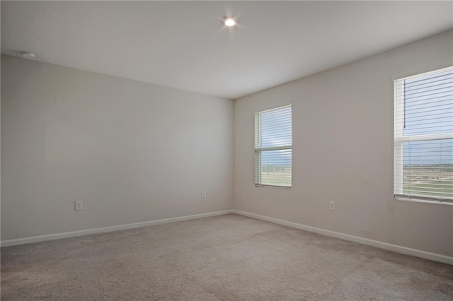 empty room with baseboards and light colored carpet