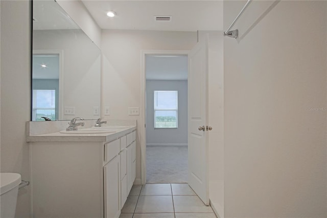 bathroom featuring double vanity, visible vents, toilet, tile patterned floors, and a sink