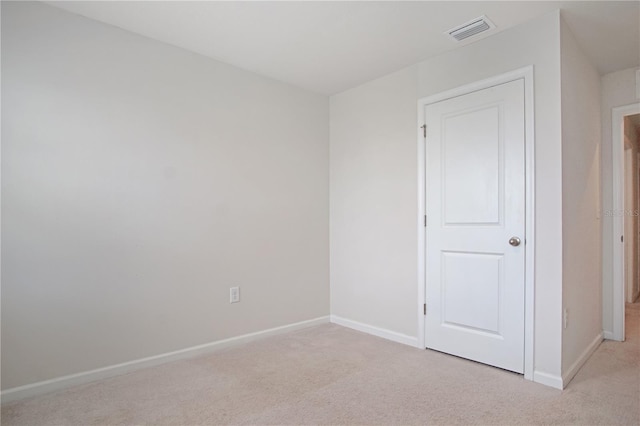 unfurnished bedroom featuring light colored carpet, visible vents, and baseboards