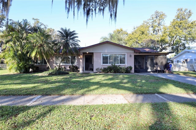 ranch-style house featuring a front yard and stucco siding