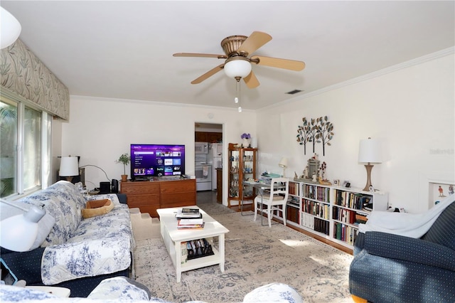 living area featuring ornamental molding, visible vents, and a ceiling fan