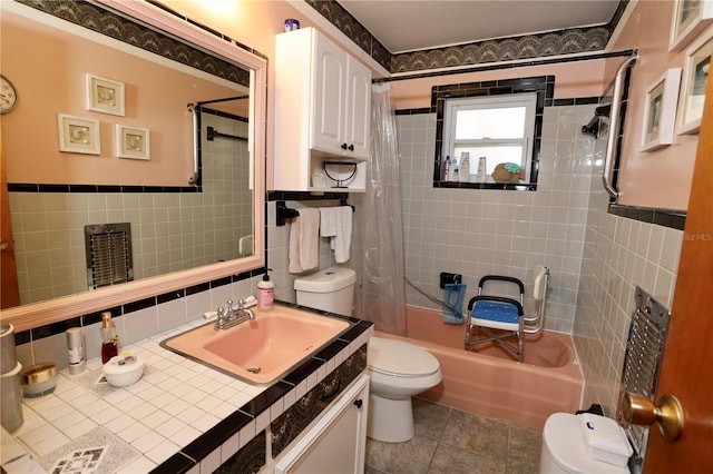 full bath featuring tile walls, toilet, and shower / bath combo with shower curtain