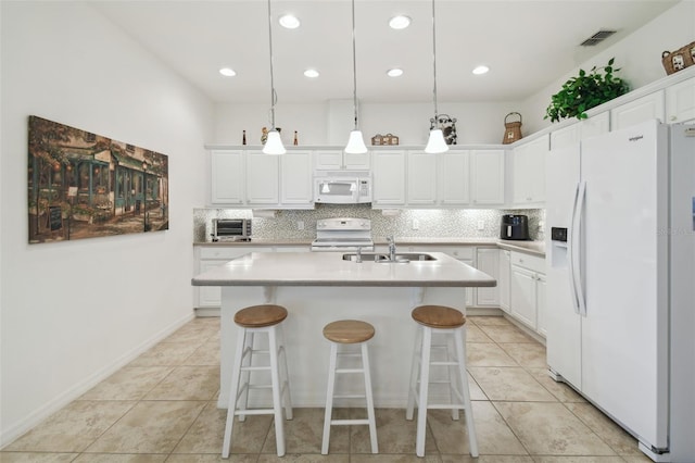 3390 Fallbrook Dr, Kissimmee, FL 34759 - kitchen with white appliances, backsplash, a sink, and white cabinets