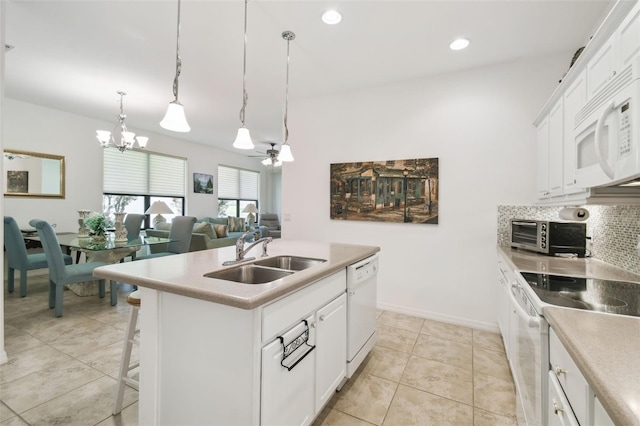 3390 Fallbrook Dr, Kissimmee, FL 34759 - kitchen featuring white appliances, a toaster, a center island with sink, a sink, and backsplash