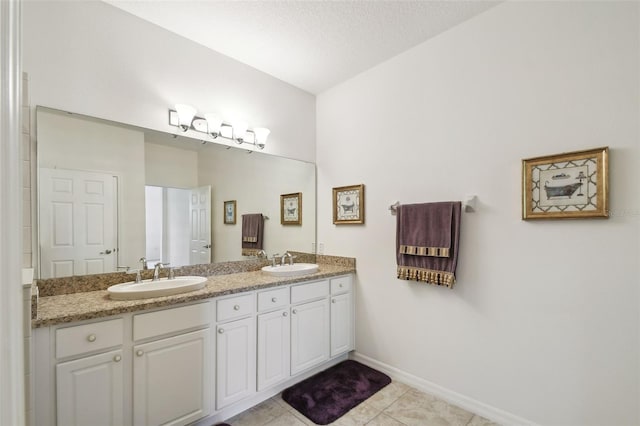 3390 Fallbrook Dr, Kissimmee, FL 34759 - bathroom featuring baseboards, double vanity, a sink, and tile patterned floors