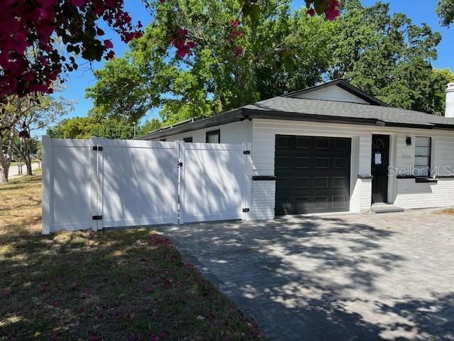 garage with driveway and a gate