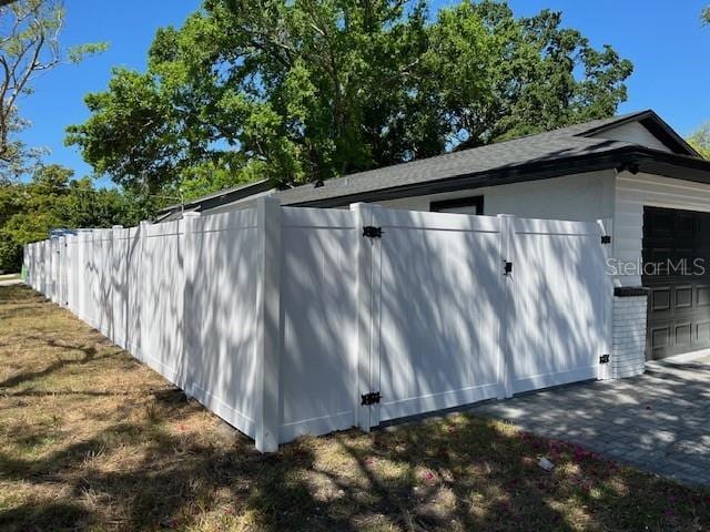 view of property exterior with a garage and fence