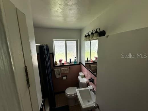 bathroom featuring toilet and a shower with shower curtain