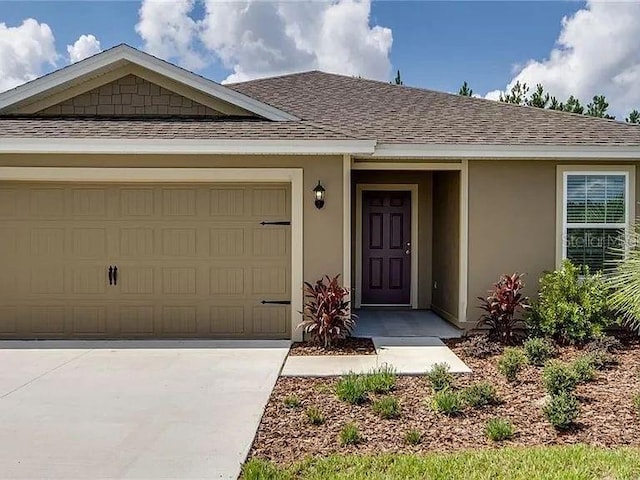 view of front of home with a garage, concrete driveway, roof with shingles, and stucco siding