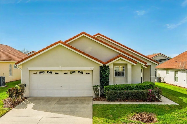 single story home with central air condition unit, a garage, driveway, stucco siding, and a front lawn