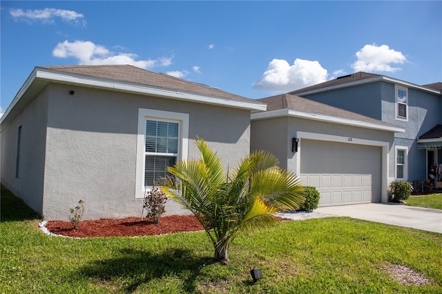 ranch-style home with concrete driveway, stucco siding, an attached garage, and a front yard